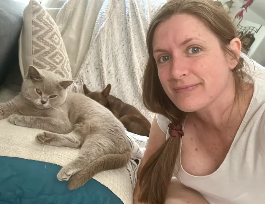 Marie assise avec plusieurs British Shorthair